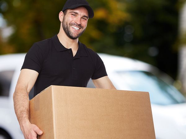 A male mover carrying a moving box