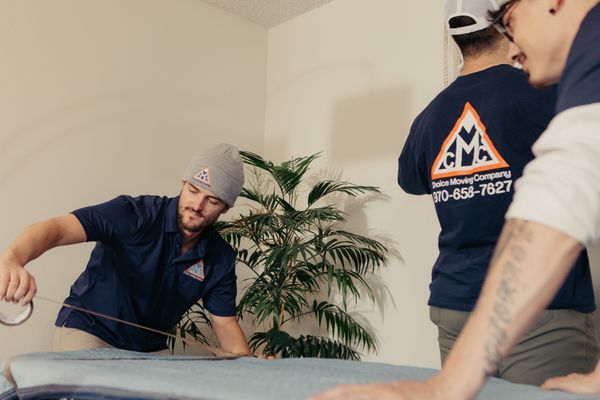 A picture of a moving crew blanketing & taping a table for protection