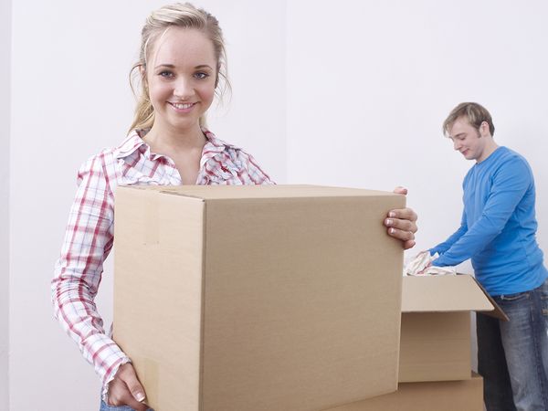 A male and female packing and moving boxes
