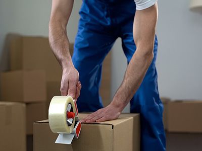 person using packing tape to seal a box
