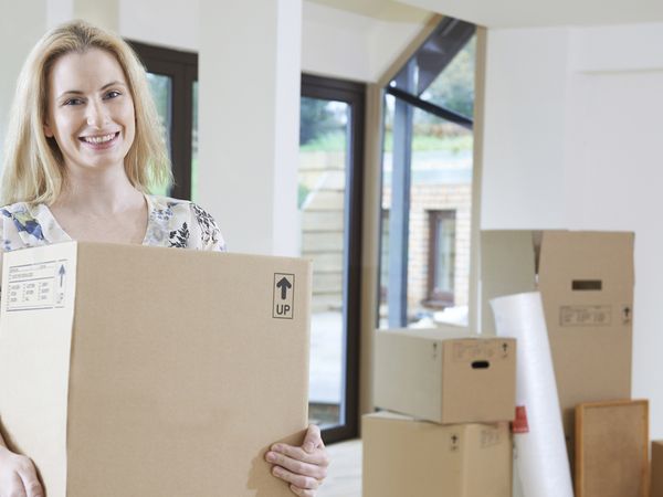 A woman carrying a moving box.