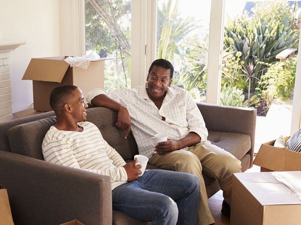 Father And Adult Son Take A Break With Pizza On Moving Day