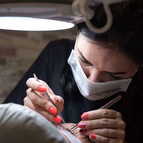 cosmetologist applying eyelash extensions