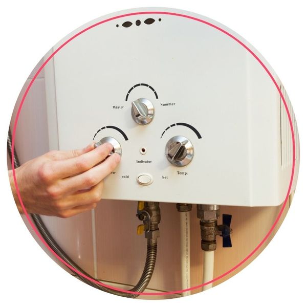 Person adjusting water heater knobs