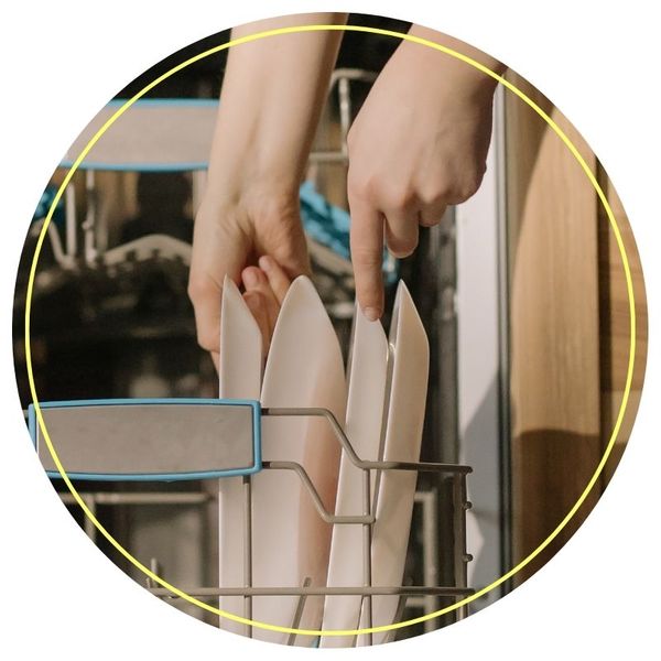 Person grabbing plates in a dishwasher