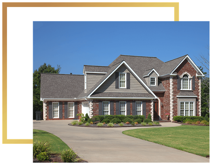 a large brick home with a pristine lawn and large driveway