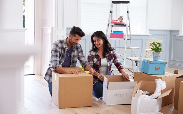 two people packing up items in a home