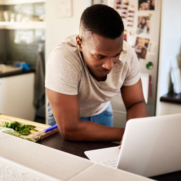 man looking at computer while in the kitchen