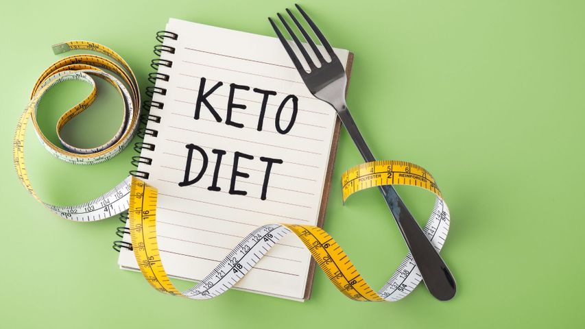 notebook reading "keto diet" with a fork and measuring tape over it