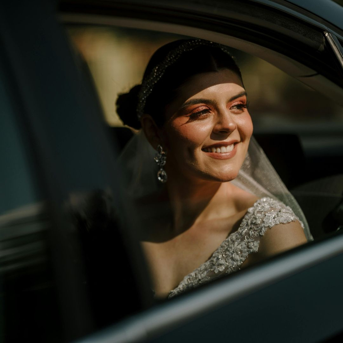happy woman in sparkly dress in backseat looking out window