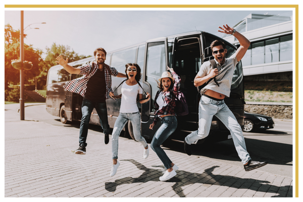 Four friends jump for a photo in front of a party bus Party Bus Rentals-4.png