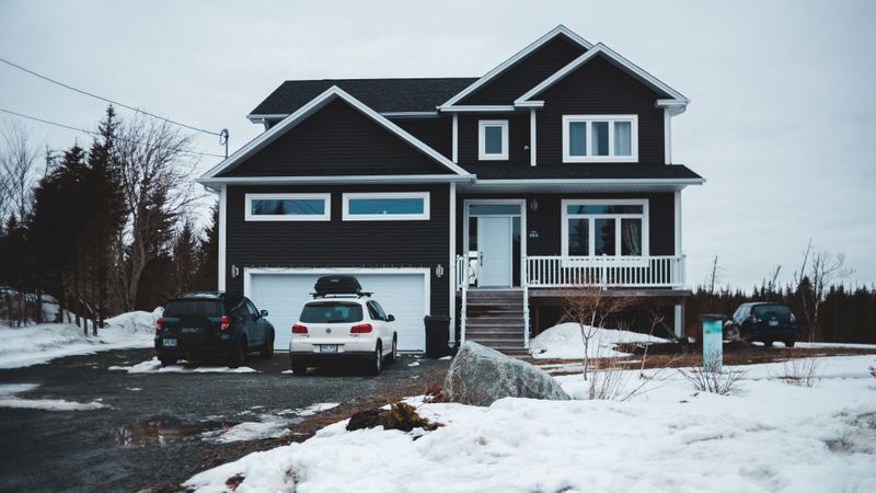 house with garage surrounded by snow house with garage surrounded by snow