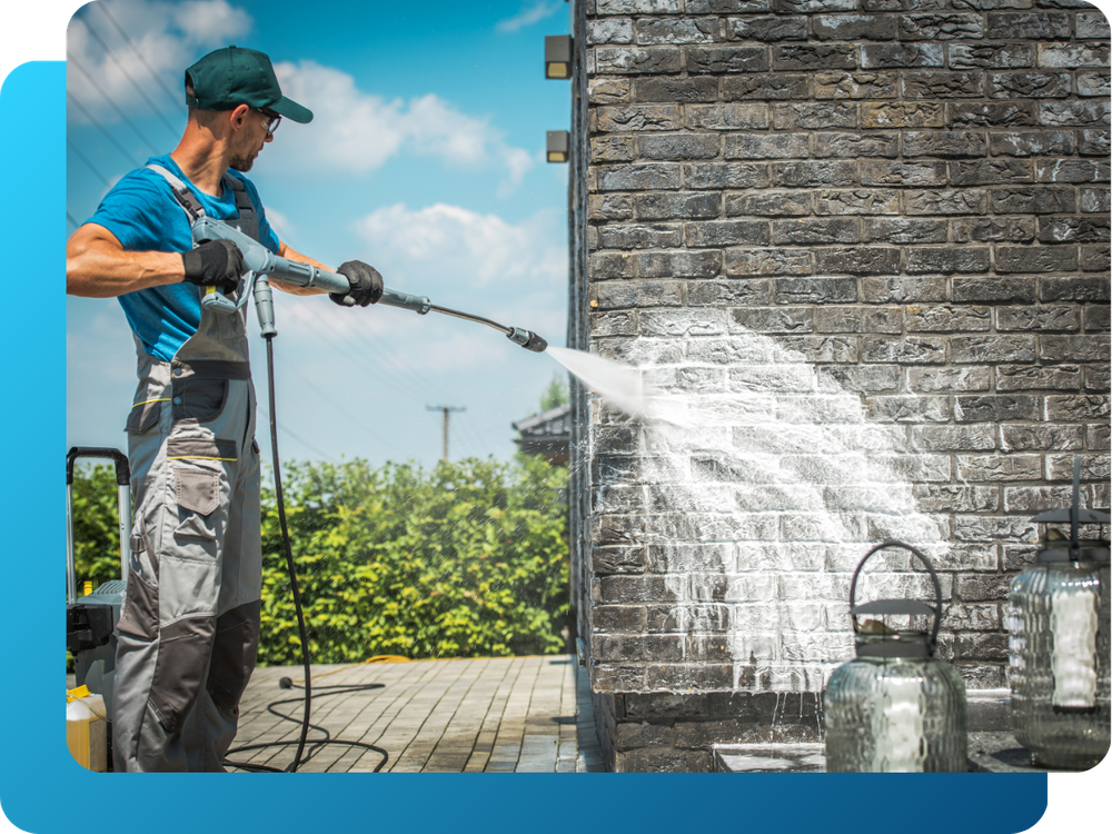 crew member pressure washing commercial brick building