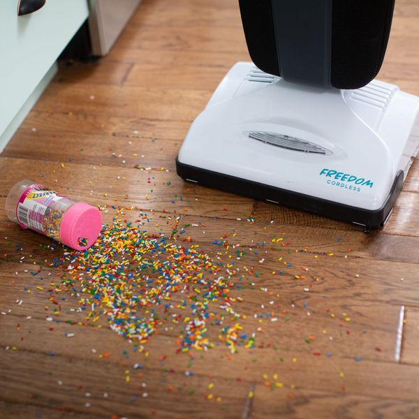 Freedom cordless vacuum cleaning up sprinkles on kitchen floor