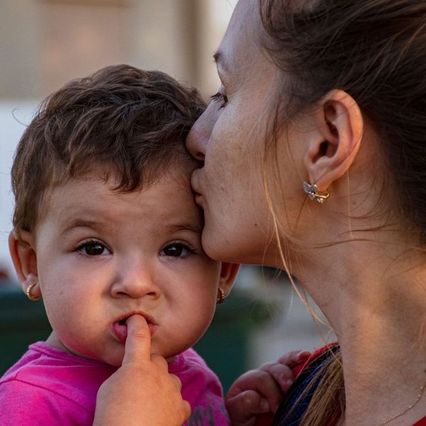 mom kissing toddler goodbye