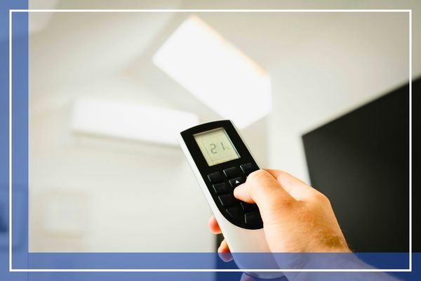 Person using a remote to turn on the AC