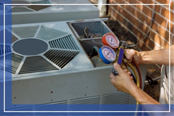 A close-up photograph capturing the gloved hands of a skilled technician adjusting gauges on an outdoor air conditioning condenser unit during a routine HVAC maintenance service.