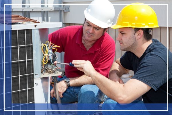 HVAC techs looking at a unit