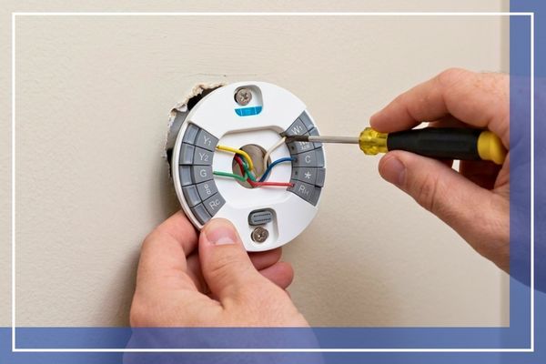 Professional technician installing a new wall thermostat.