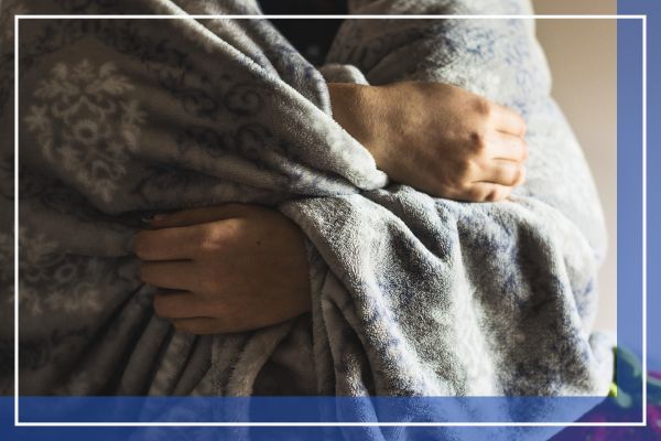 person at home bundled in a blanket