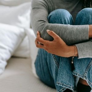 woman holding knees to chest 