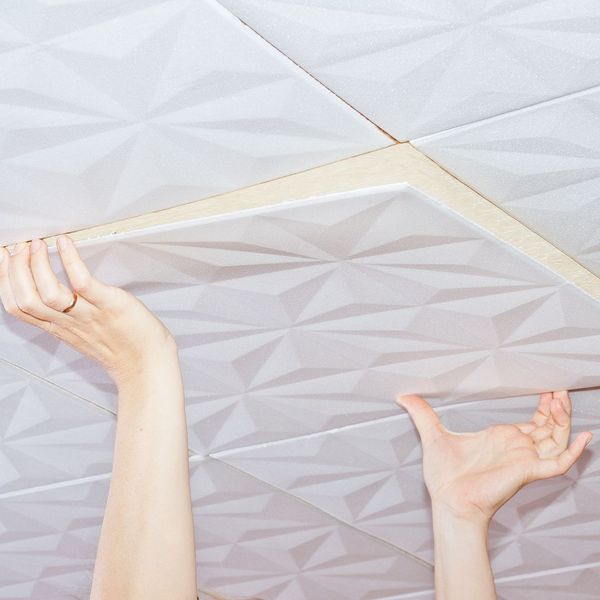 person installing ceiling tiles