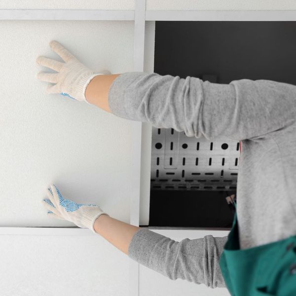 person installing ceiling tiles