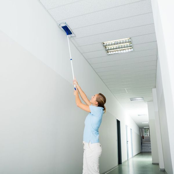 woman cleaning an acoustical ceiling