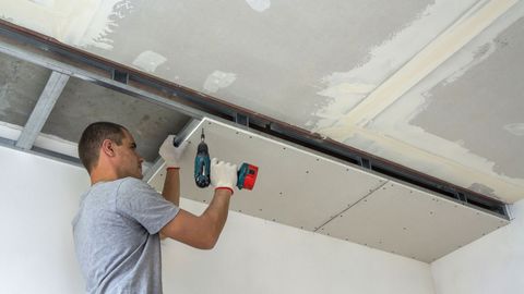 person installing a suspended ceiling