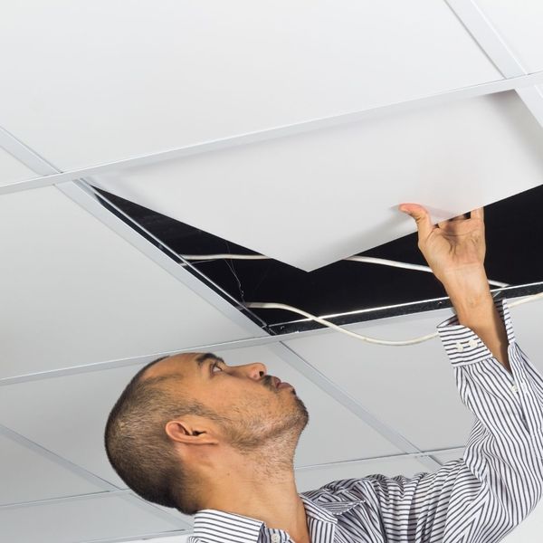 Man removing a suspended ceiling tile