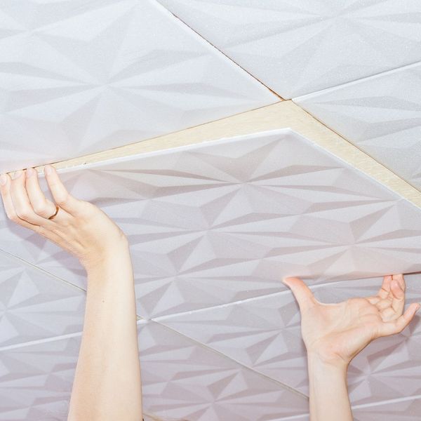 Person installing acoustic ceiling tiles. 