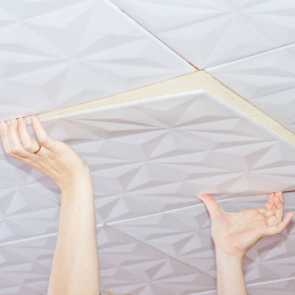 Person installing acoustic ceiling tiles. 