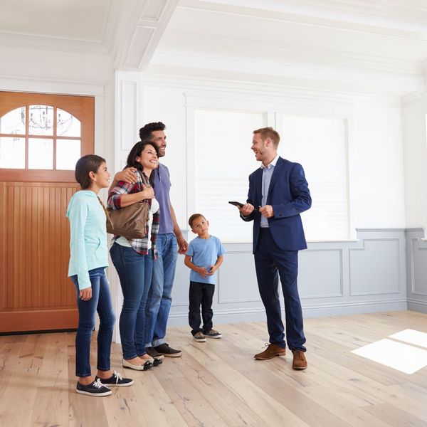 real estate agent showing home to family