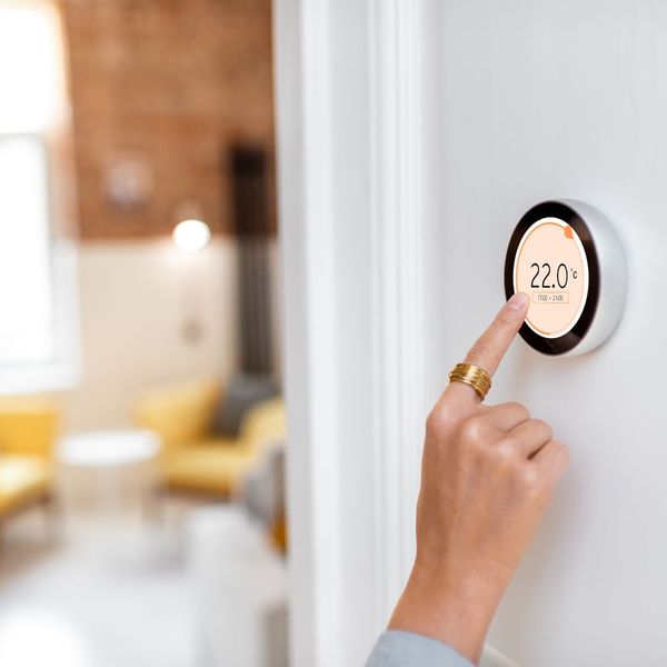 person adjusting a thermostat