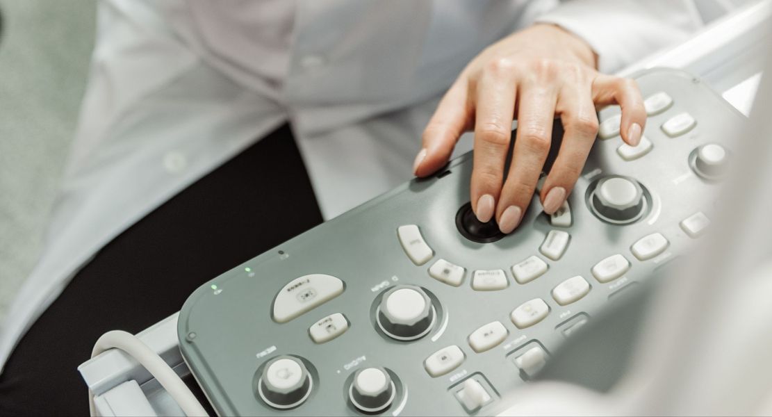 A woman working an ultrasound machine. A woman working an ultrasound machine.