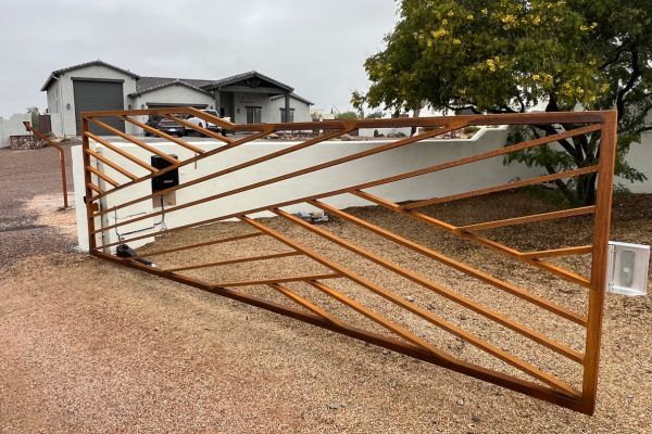 metal gate attached to stucco wall over gravel Gates 3.jpg