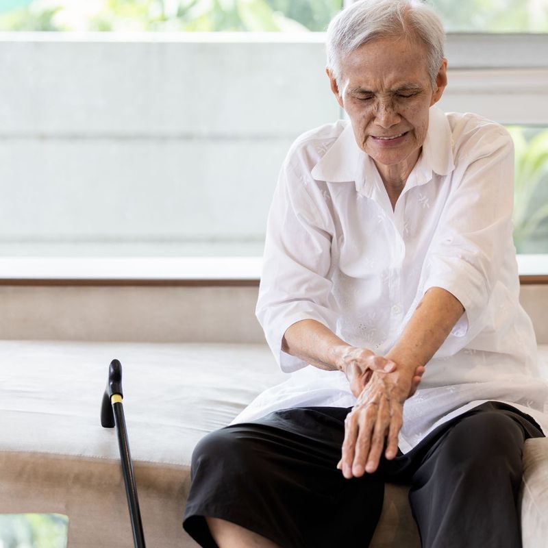 man sitting down and holding his wrist