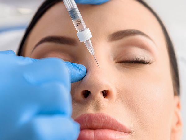 Image of a woman getting and injection into her nose