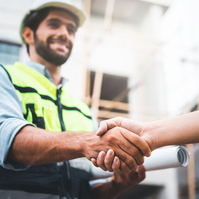 Construction worker shaking hands with someone off screen