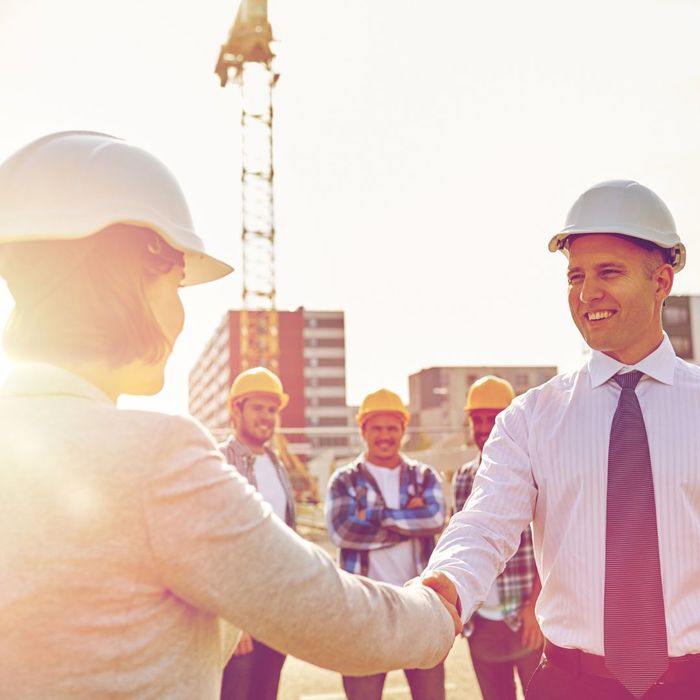 people shaking hands at construction site people shaking hands at construction site