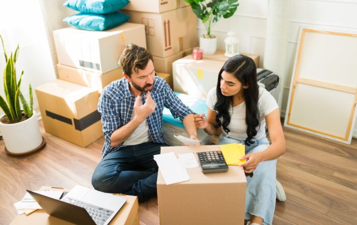 couple calculating cost of move with moving boxes around