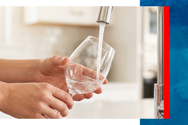 A detailed close-up photograph capturing hands with soft skin rinsing a perfectly clear, spot-free crystal wine glass under a stream of clean water from a modern faucet, illustrating the spotless results provided by Aqua Doctor's water softening systems in