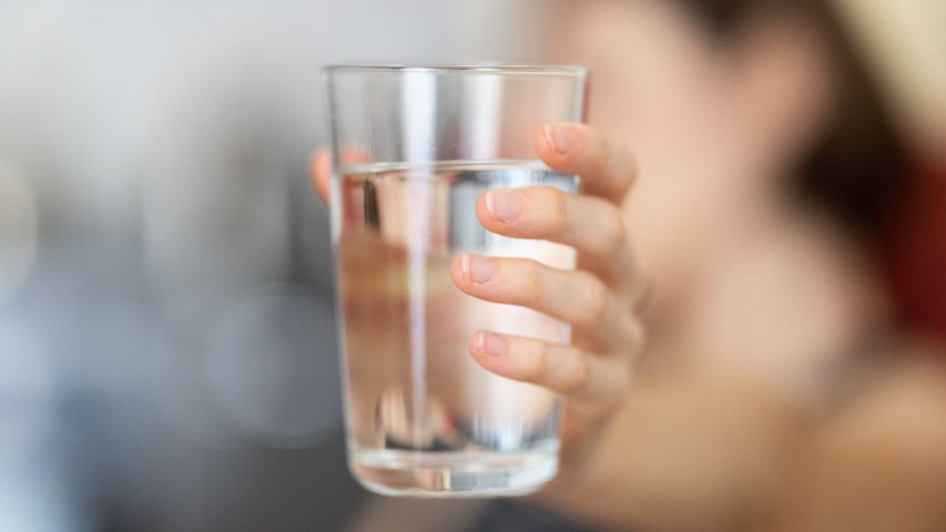 Person holding glass of water