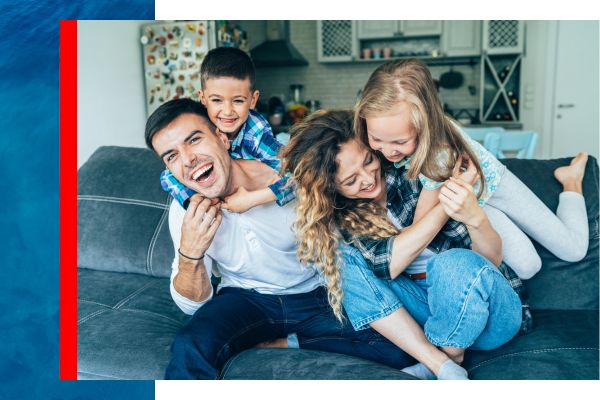 Happy family laughing and hugging on a couch