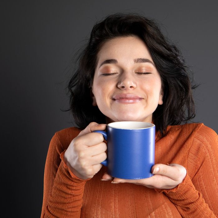 woman smelling coffee cup