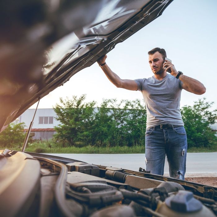 man inspecting car engine