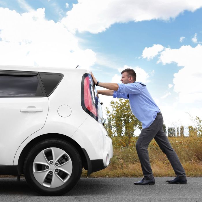 man pushing car