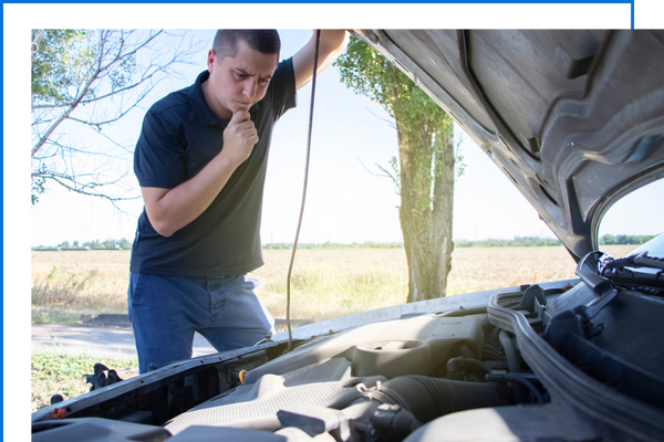 man looking at car engine