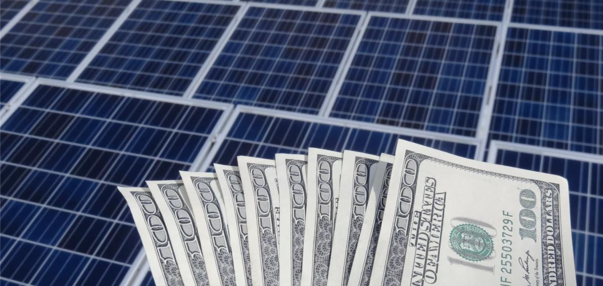 63add083910c706551bad510_money fanned out on top of solar panels.jpg