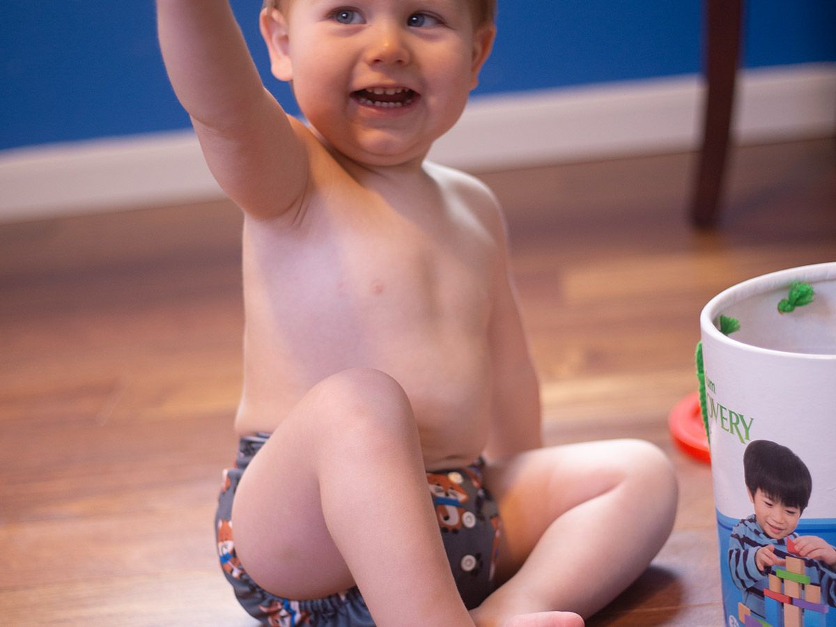 Child playing with blocks while wearing a diaper from Bum Baby Bum.